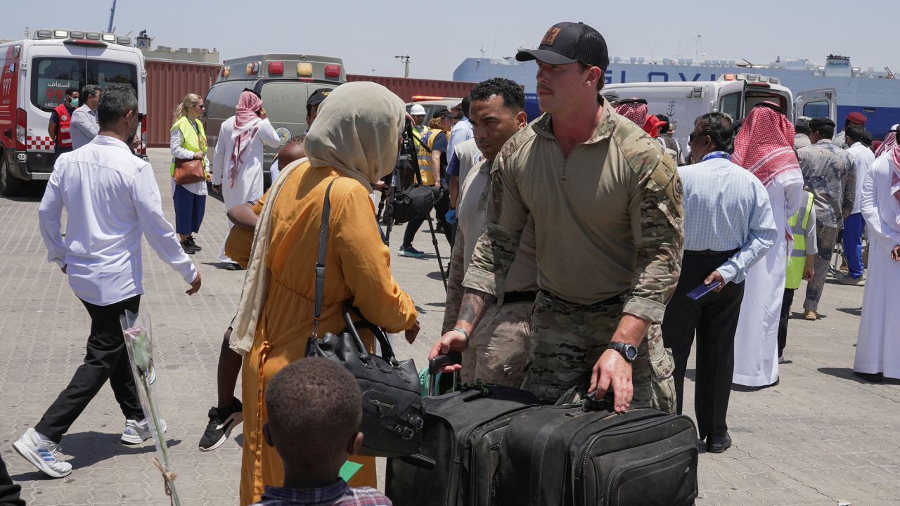 US Navy officials help evacuees disembark from the US Navy fast transport ship, the USNS Brunswick, which arrived to Saudi Arabia from Sudan on May 1.