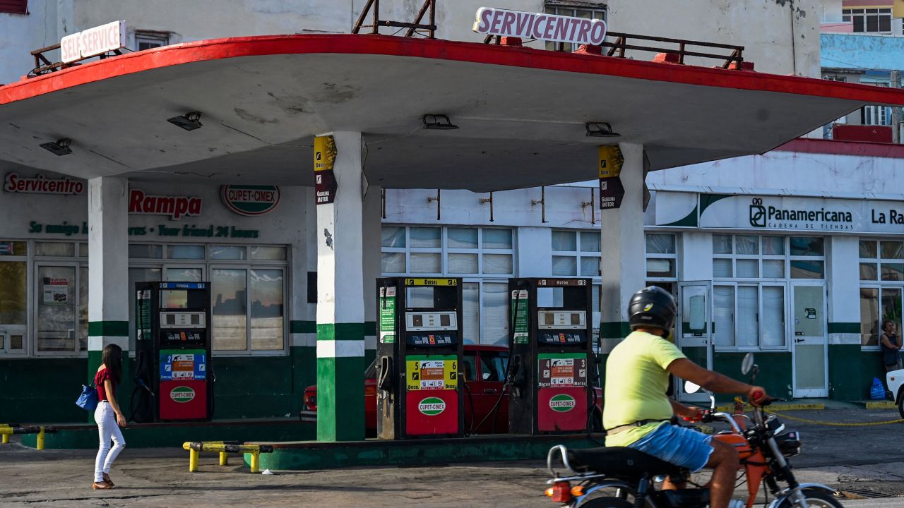 A man riding a motorcycle passes by an empty gas station in Havana on April 24, 2023. 