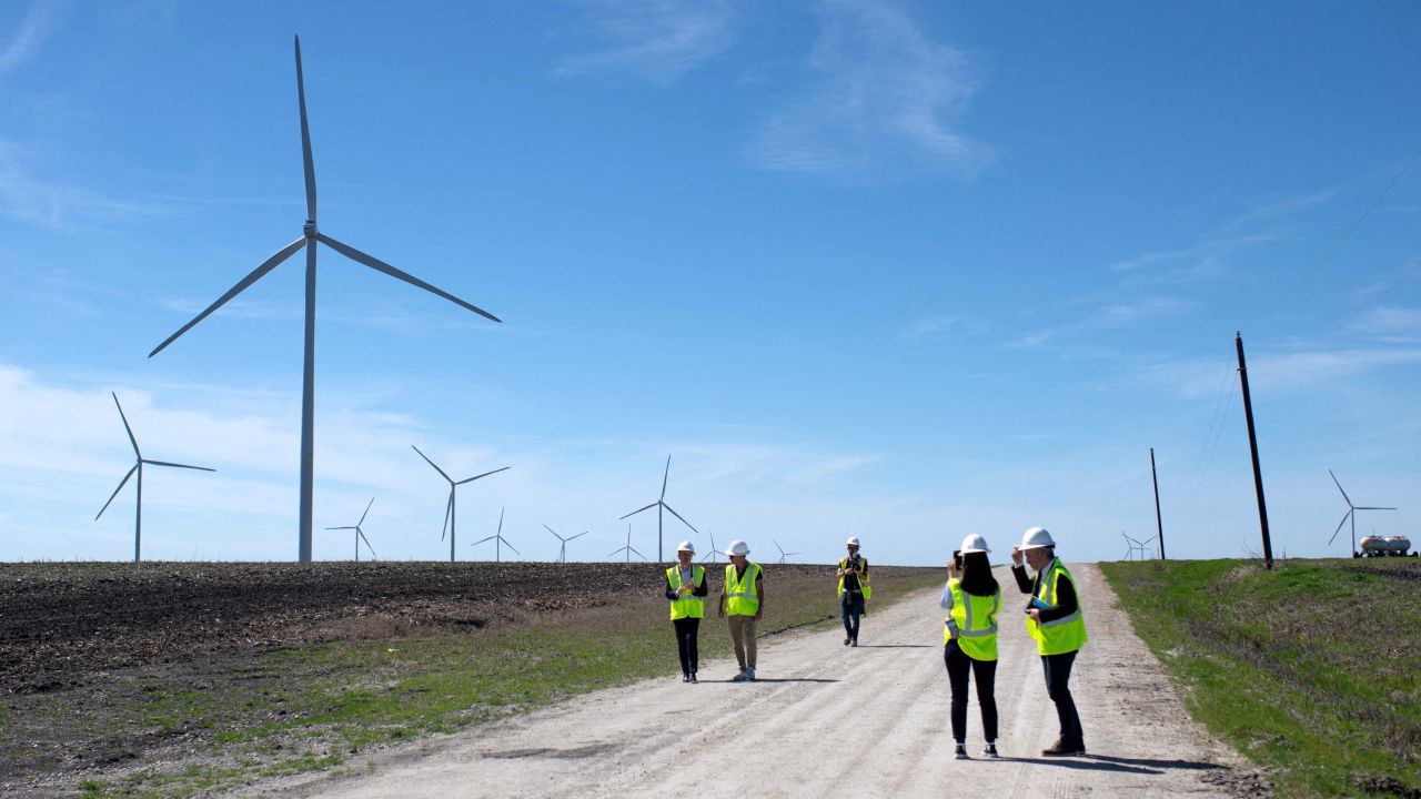Engie employees walk down a road for a closer look at wind turbines during a tour for the dedication of the Limestone Wind Project in Dawson, Texas, on February 28, 2023. 
