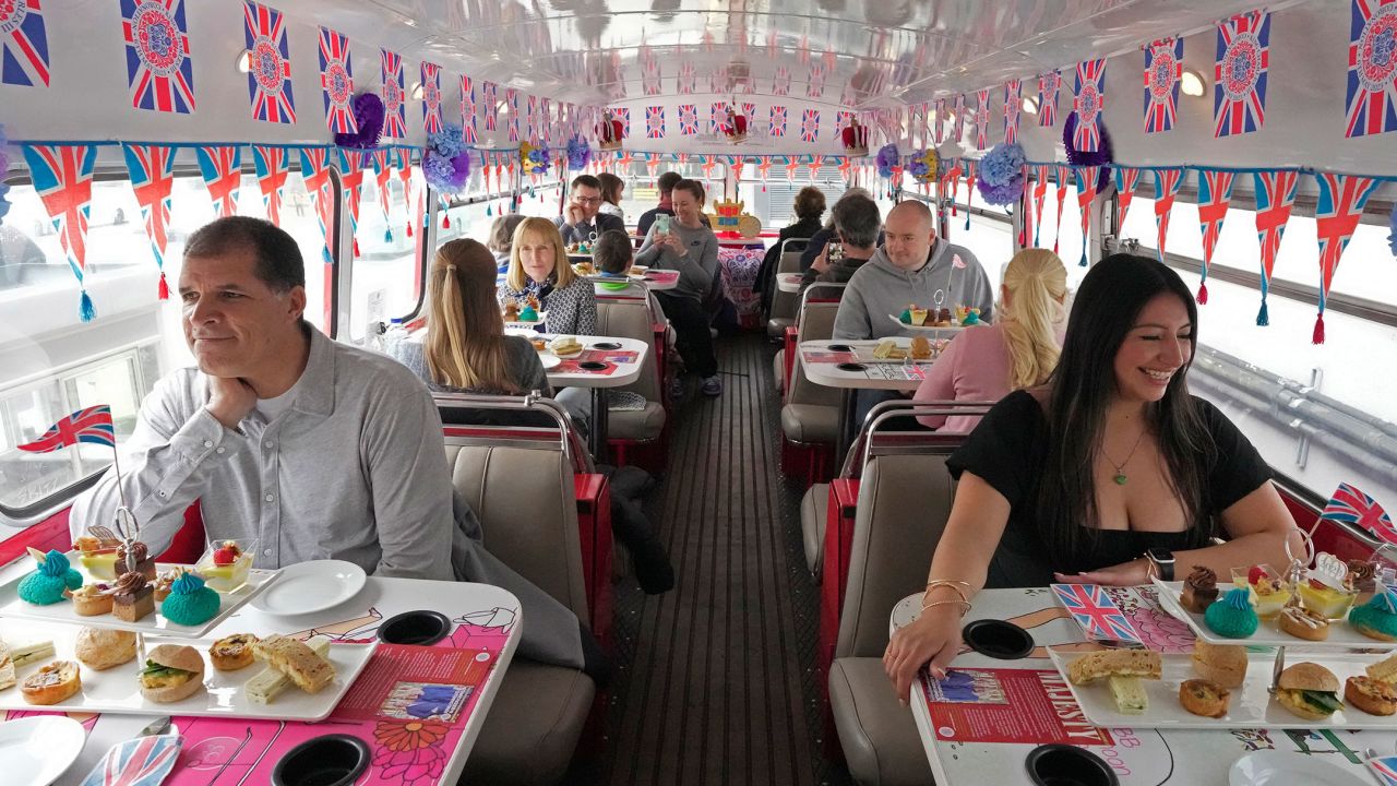 Tourists sit on a coronation tour bus, in London on Monday, April 24, 2023.