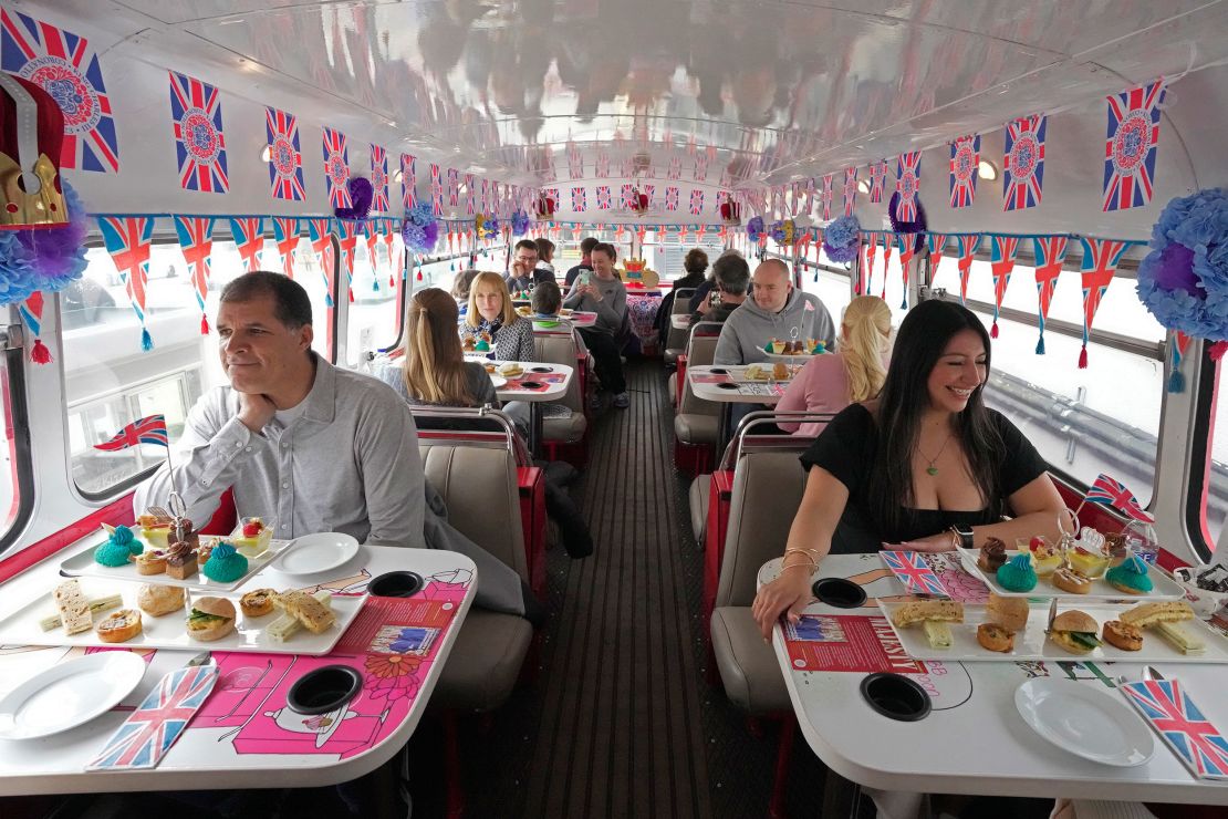 Tourists sit on a coronation tour bus, in London on Monday, April 24, 2023.