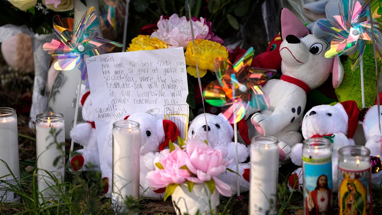 A letter is among the items left by neighbors during a vigil Monday outside the home where the mass shooting unfolded.