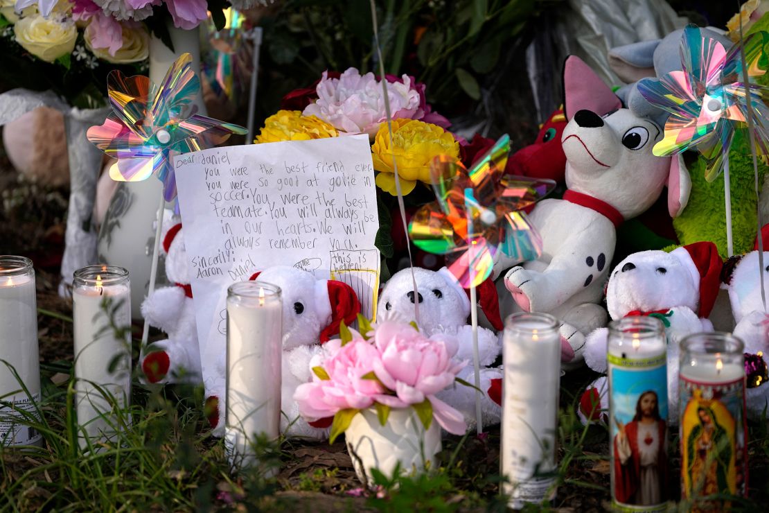 A letter sits among items left by neighbors during a vigil Monday outside the home where the mass shooting unfolded.