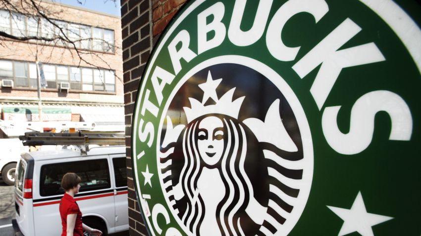 A woman walks past a Starbucks store in Somerville, Massachusetts April 24, 2008. U.S. stocks fell on Thursday, hurt by a drop in new home sales and disappointing outlooks from online retailer Amazon.com and coffee chain Starbucks that raised concerns about consumer spending. REUTERS/Brian Snyder (UNITED STATES)