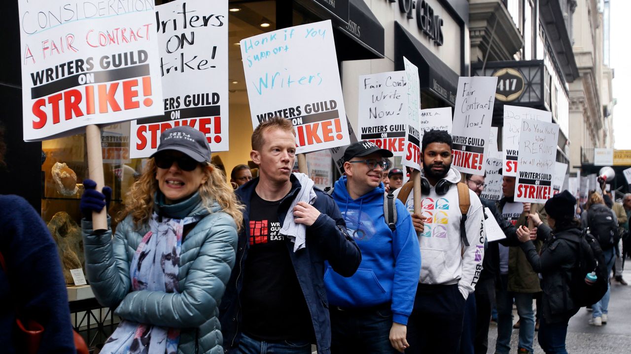 Demonstrators carry signs during a screenwriter's strike in New York City on May 2, 2023.