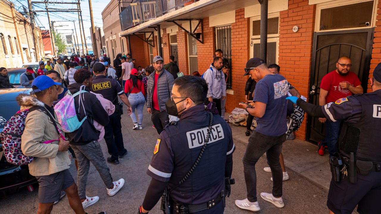 Police officers briefly remove migrants from a downtown alley to allow the clean up of a camp in El Paso, Texas, on Sunday, April 30, 2023. 
