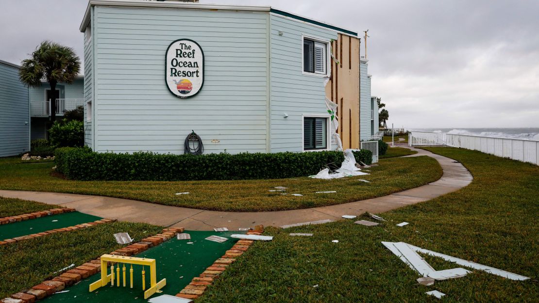Siding hangs from building in November 2022 at The Reef Ocean Resort in Vero Beach, Florida, after Hurricane Nicole made landfall.