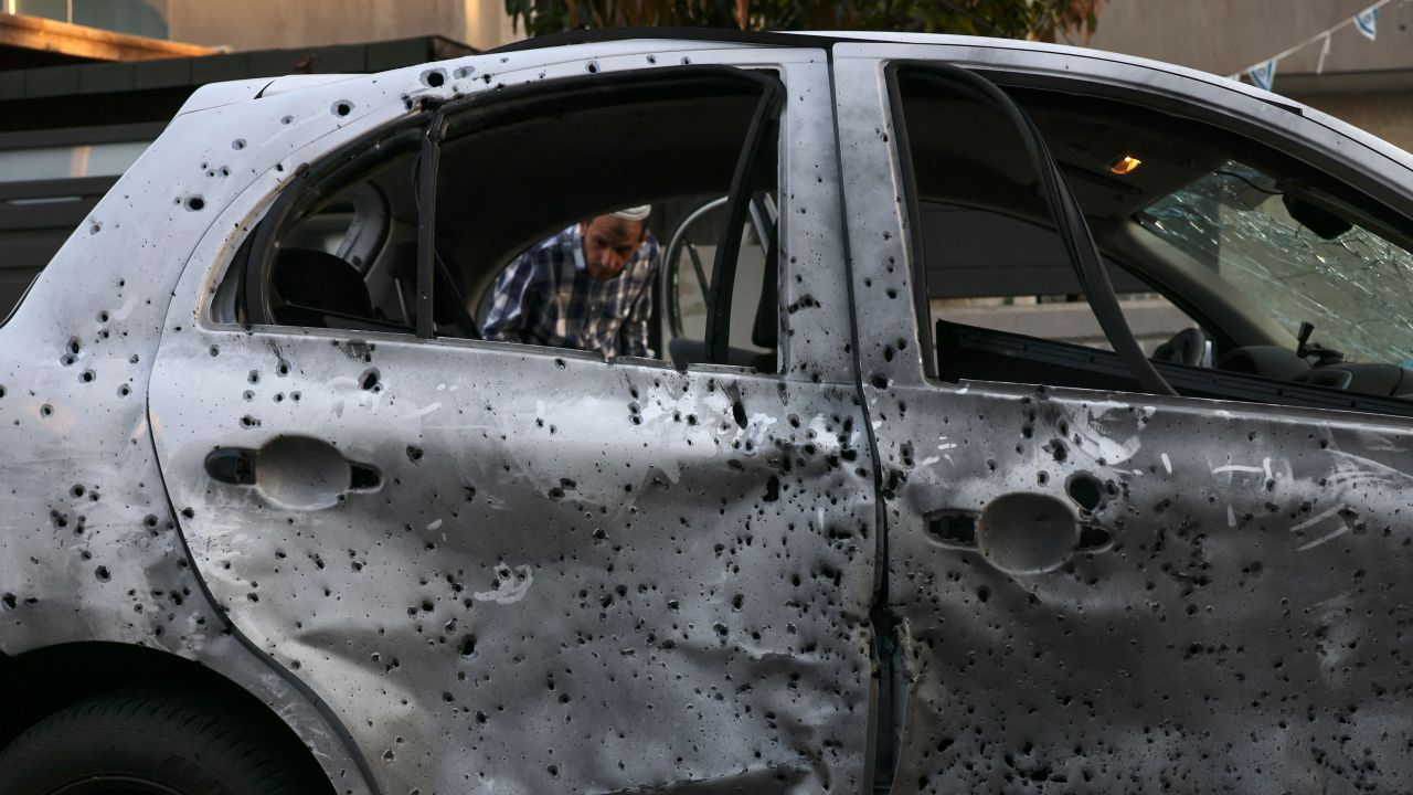 A man looks at a car damaged by a rocket from the Gaza Strip in the southern Israeli city of Sderot on May 2, 2023.