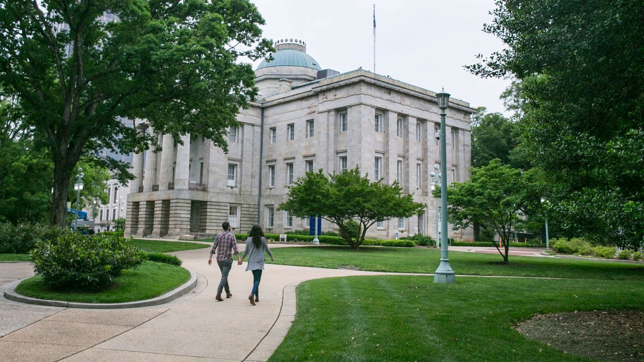 A couple walk near the North Carolina State Capitol in Raleigh, North Carolina, on Monday, May 9, 2016. 
