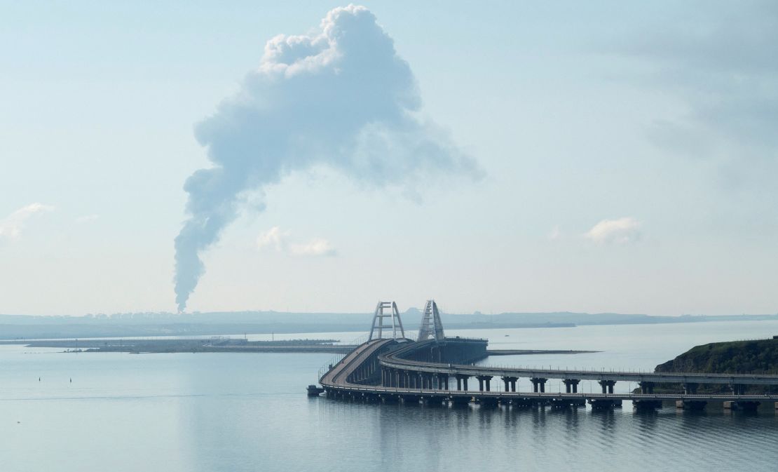 A view across the Kerch Strait shows smoke rising above a fuel depot near the Crimean bridge in the village of Volna in Russia's Krasnodar region, as seen from a coastline in Crimea, on May 3, 2023.