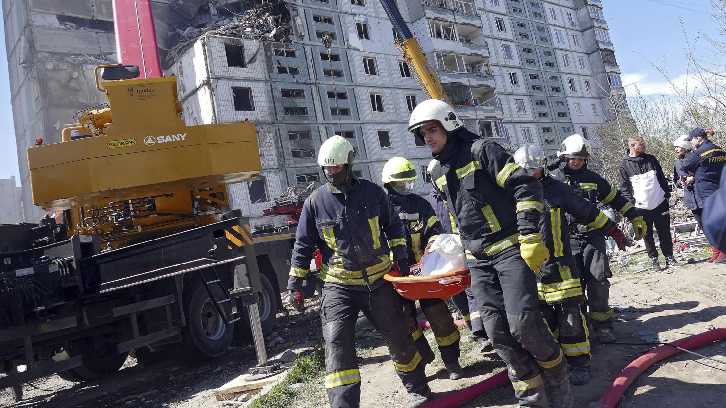 Rescuers carry the body of a victim found under the rubble at a block of flats destroyed in a Russian rocket attack on Uman, in central Ukraine's Cherkasy region, on April 28, 2023.