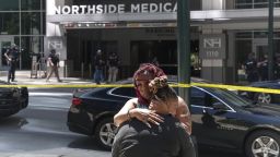 ATLANTA, GA - MAY 3: Angela Cooper and Jamese Nathan embrace outside of Northside Hospital medical facility as police officers work the scene of a shooting on May 3, 2023 in Atlanta, Georgia. Police say one person was killed and four others injured in the shooting and the suspect is still at large. (Photo by Megan Varner/Getty Images)