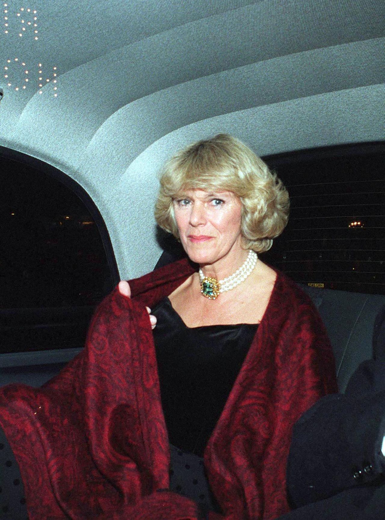 At a party at The Ritz in London in 1995, Camilla donned one of her favorite jewelry pieces: A three strand pearl necklace completed by a central aquamarine stone, paired with an off-the-shoulder black cocktail dress.