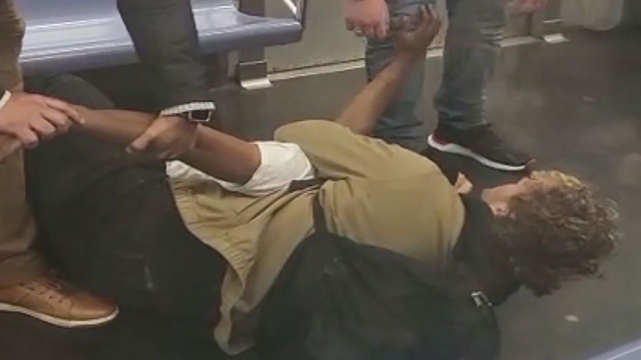 A video screengrab shows Jordan Neely and another man on the subway car floor with the man's arm wrapped around Neely's neck. CNN has not been able to independently confirm what happened leading up to the incident and doesn't know how long Neely was restrained or whether he was armed.