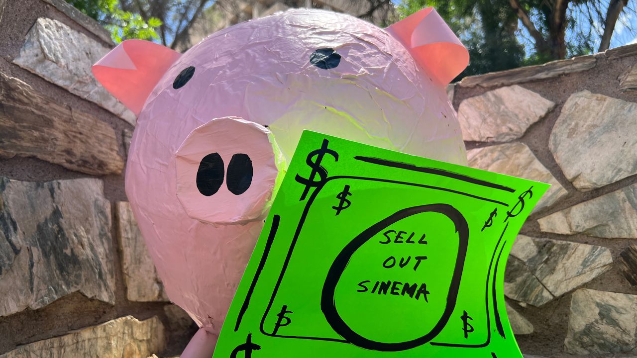A pig prop with a sign that reads "Sell Out Sinema" is seen at a news conference in Phoenix.