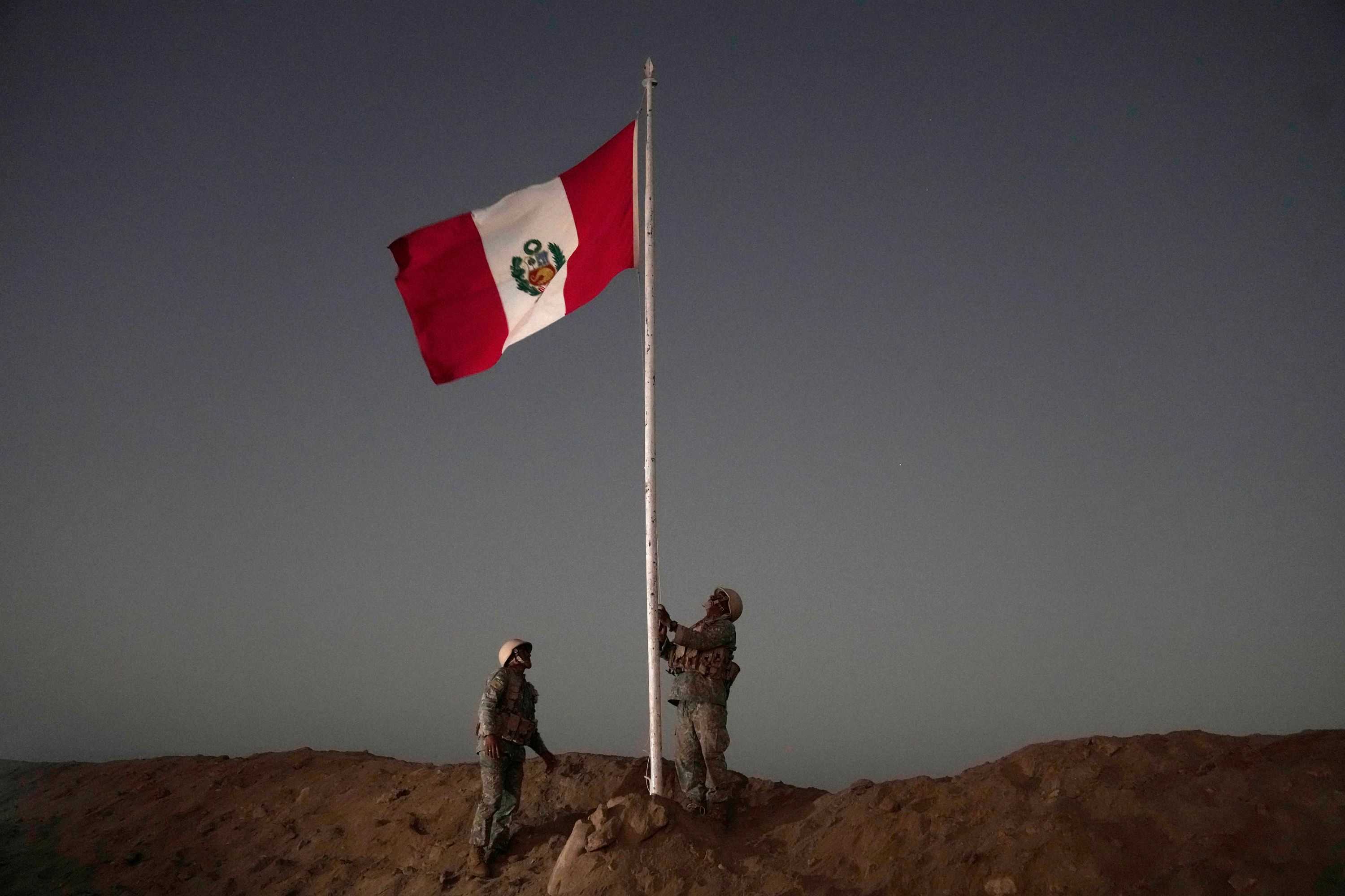 Peruvian soldiers raise their country's national flag in Tacna, Peru.