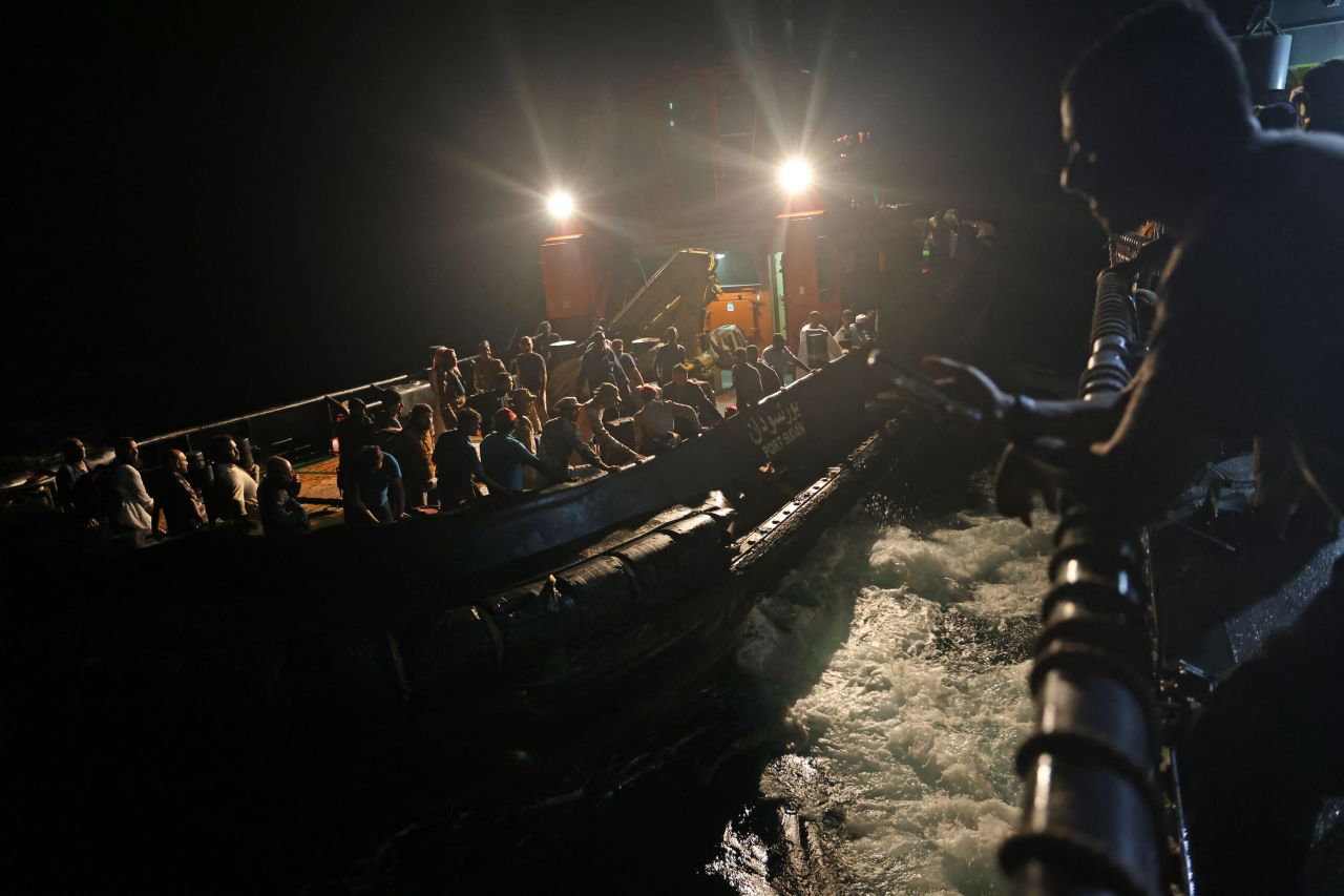 Evacuees are transported aboard a tugboat before boarding a Saudi vessel to leave <a href=