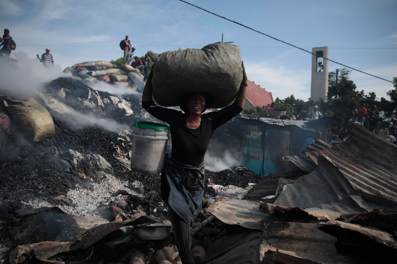 A vendor salvages items from the burned ruins of the Shada Market in Pétion-Ville, Haiti, on Thursday, May 4. The cause of the fire wasn't immediately clear, <a href=