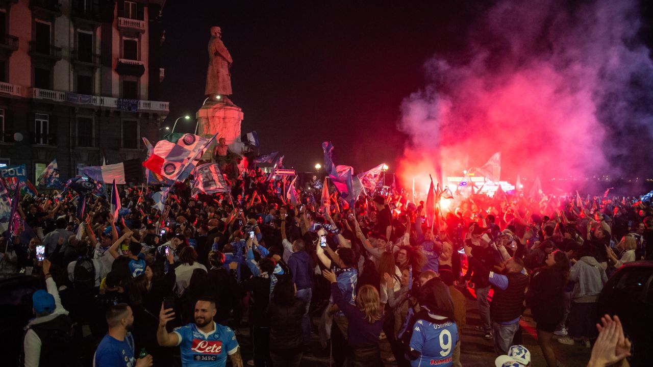 NAPLES, ITALY - MAY 04: Napoli fans celebrate after winning the Serie A championship near the mural of Diego Armando Maradona on May 04, 2023 in Naples, Italy. SSC Napoli are Champions of Italy after thirty three years; the last time they obtained the trophy, Diego Armando Maradona led the team. The victory of the third Scudetto comes for the team coached by Luciano Spalletti, obtaining 1 point away at the Friuli stadium against Udinese. (Photo by Ivan Romano/Getty Images)