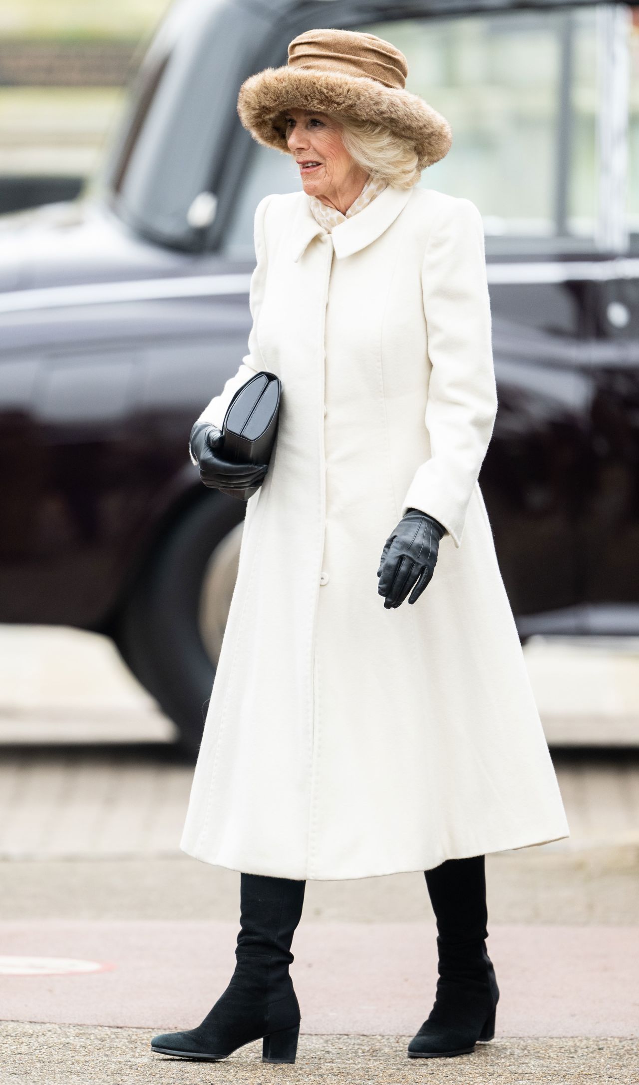 During a visit to Colchester Castle in March, 2023, Camilla was spotted in a chic white dress coat. Her commitment to cosiness is always present, however, demonstrated here with her wide-brim, fur-trimmed hat. 