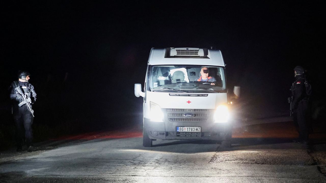 An ambulance passes through a checkpoint during the aftermath of a shooting in Dubona, Serbia, on May 5, 2023.