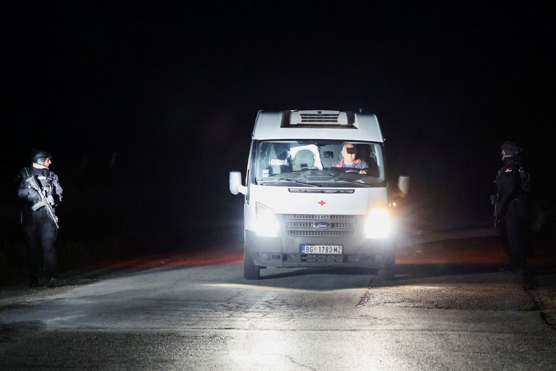 An ambulance passes through a checkpoint during the aftermath of a shooting in Dubona, Serbia, on May 5, 2023.