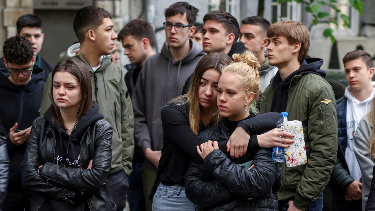 Los dolientes visitan un monumento improvisado en Belgrado después del tiroteo del miércoles. 