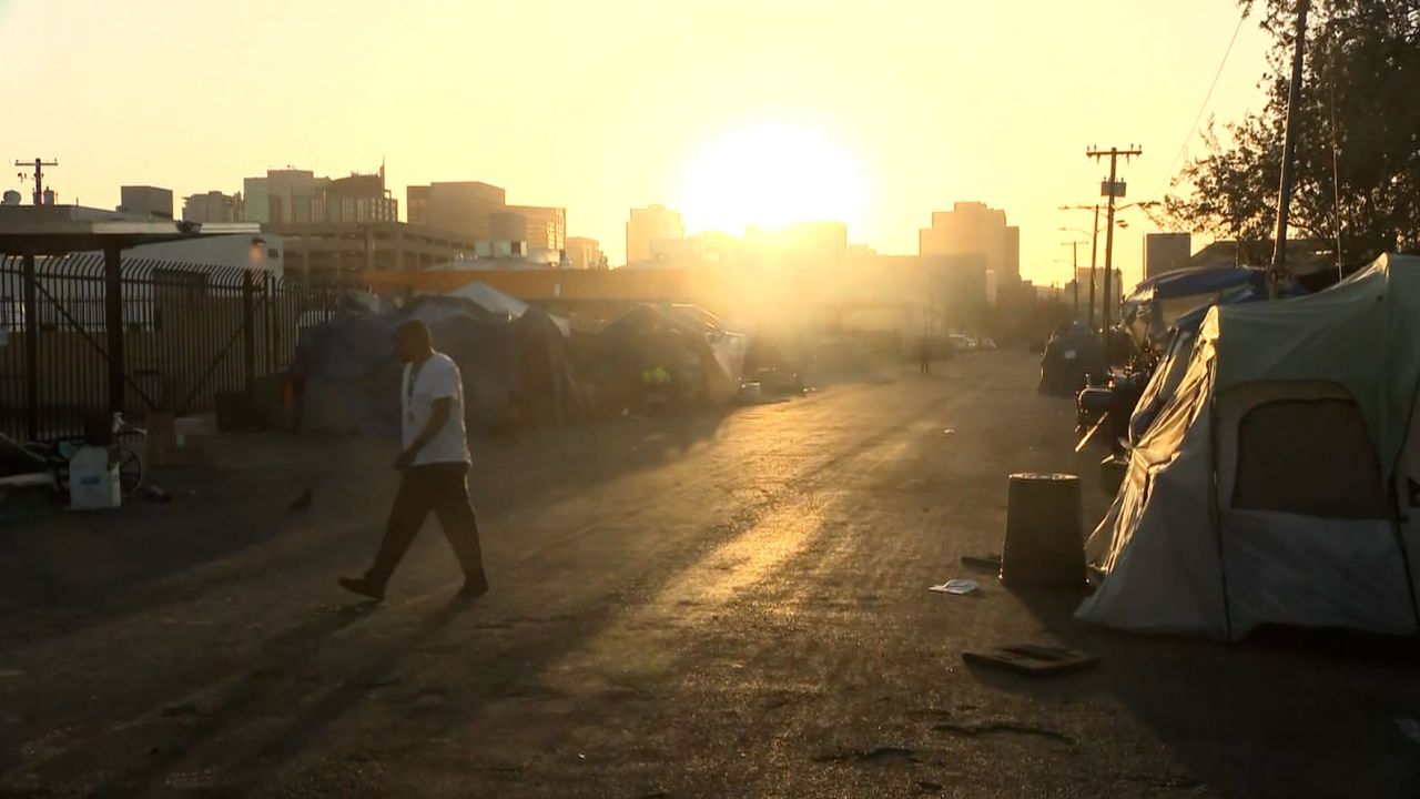A person walks through a homeless encampment on April 18 in Phoenix.