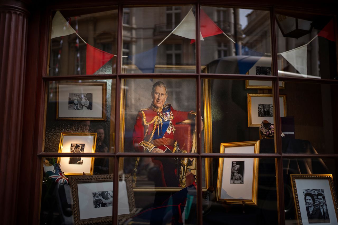 A storefront window in London is decorated with framed photographs and a painting of the King on Thursday.