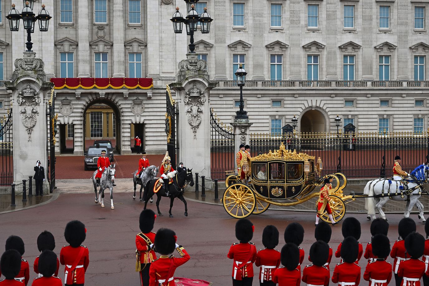 The King's carriage leaves Buckingham Palace before the coronation.