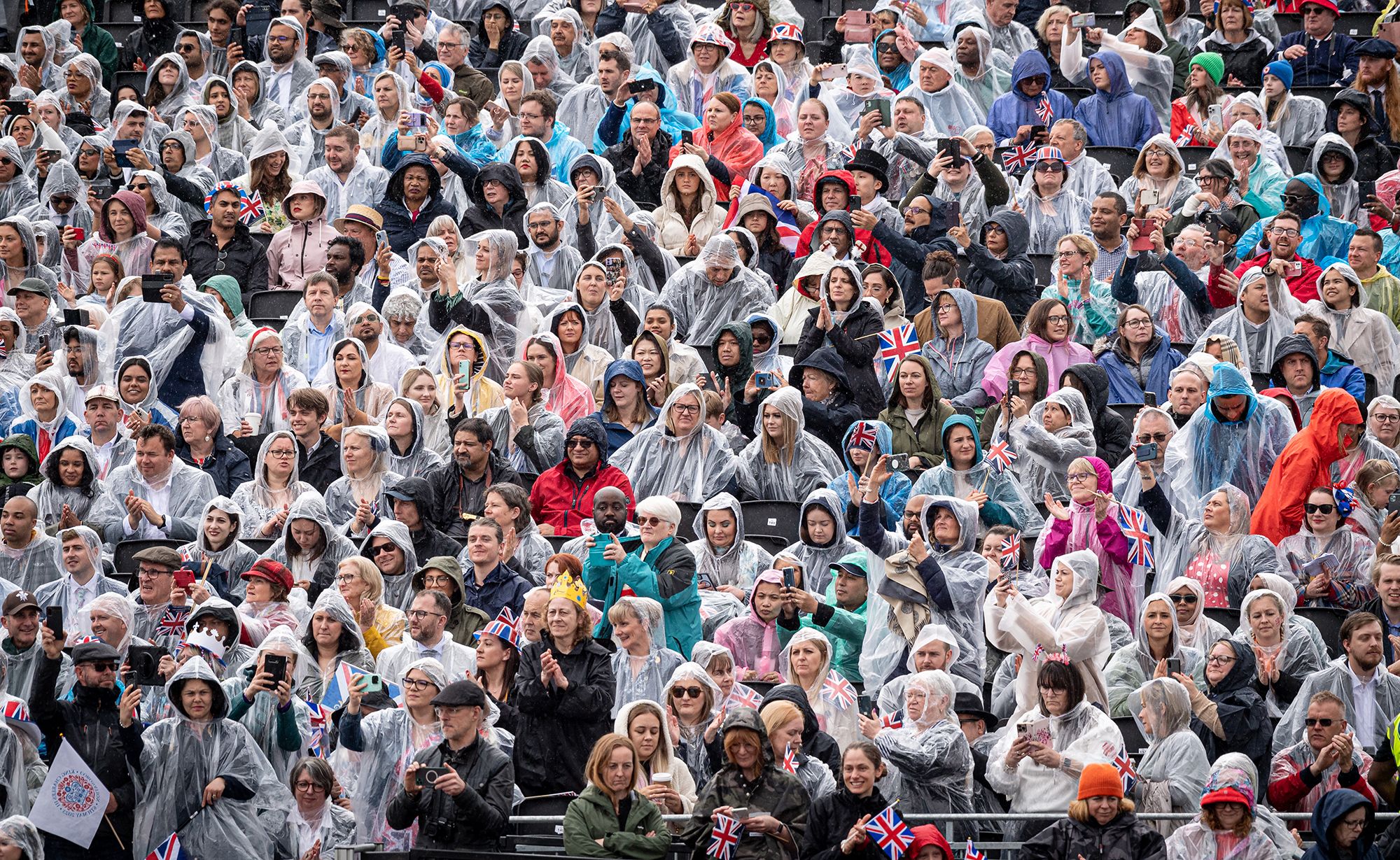 People gather to watch the procession. Showers moved through London on Friday.