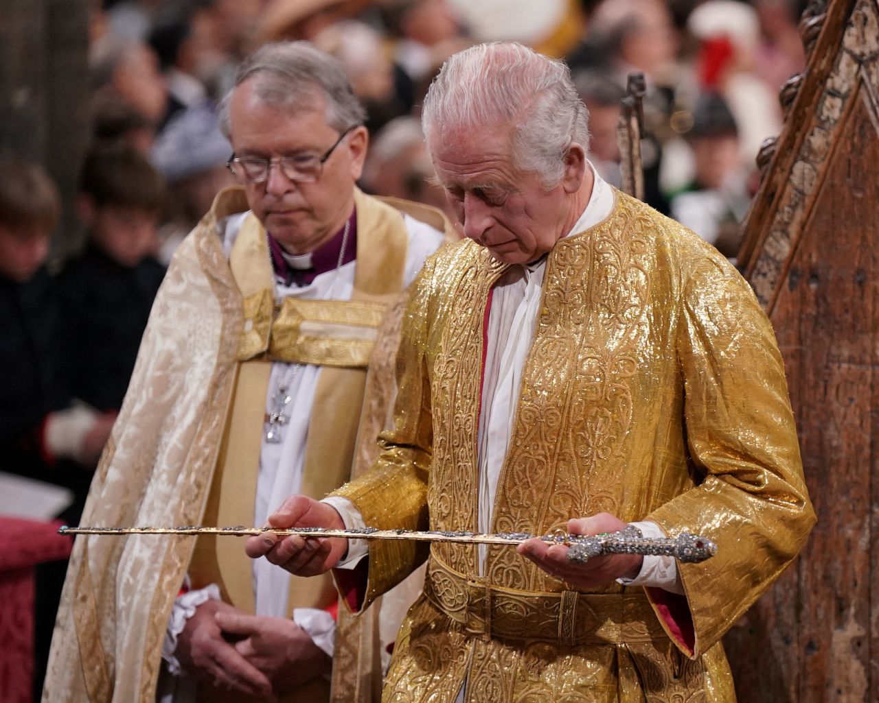 The King holds a sword during the ceremony.