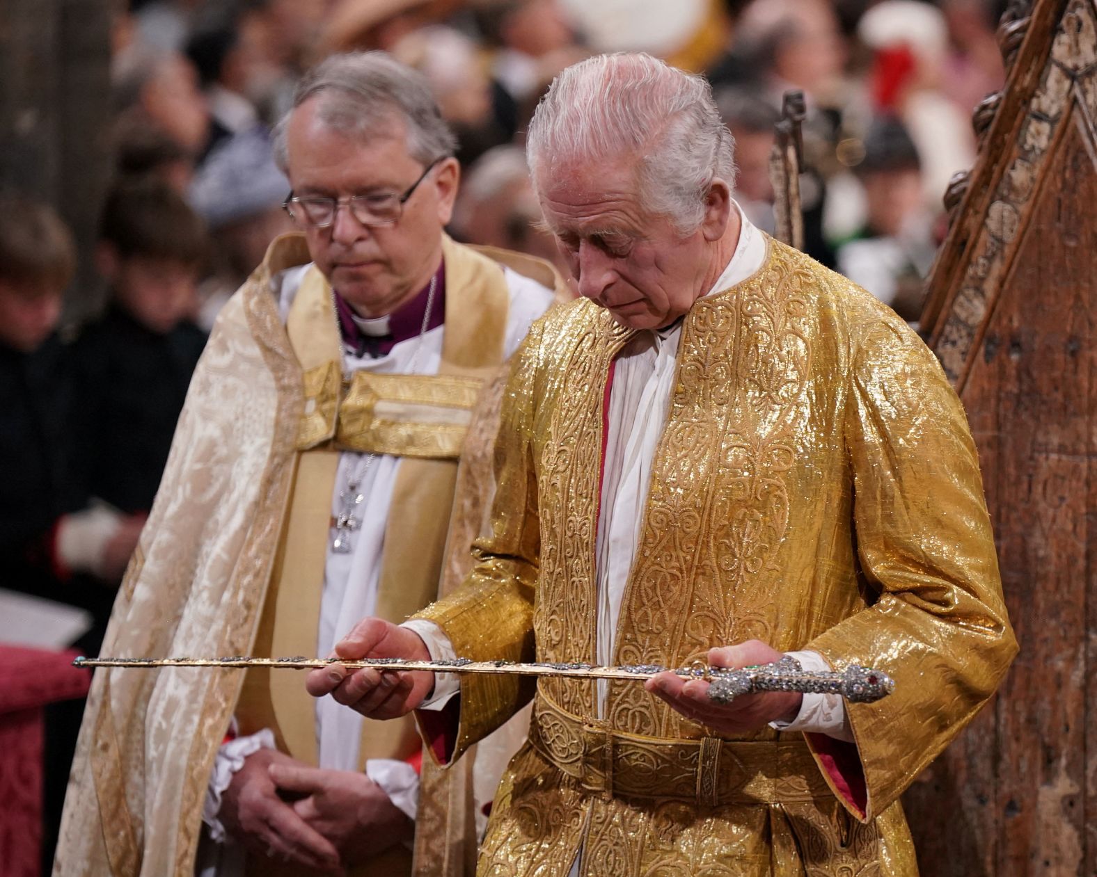 The King holds a sword during the ceremony.