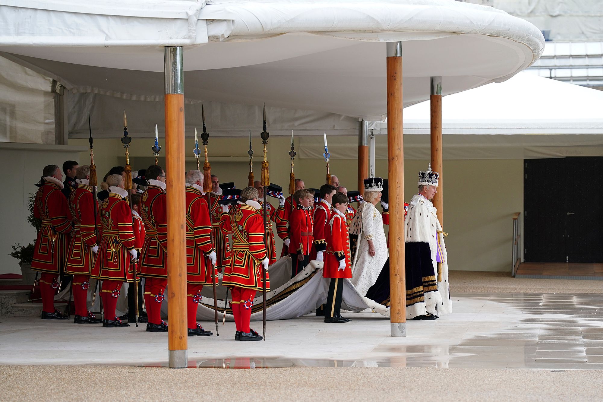 The King and Queen arrive at the palace to receive a royal salute from members of the military.