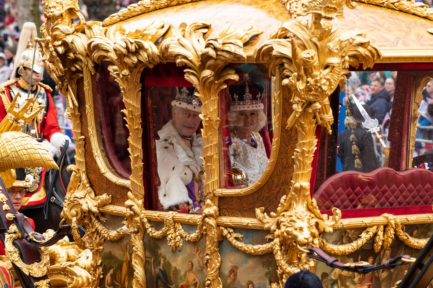 The King and Queen travel to Buckingham Palace in the Gold State Coach after the coronation ceremony at Westminster Abbey.
