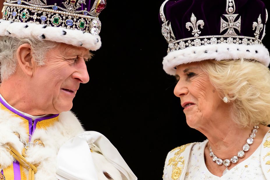 The King and Queen look at each other on the balcony. They gave an <a href="https://www.cnn.com/uk/live-news/king-charles-iii-coronation-ckc-intl-gbr/h_0ae57785e308be74beafa7bcdf37b334" target="_blank">encore wave</a> to the crowd after initially going back inside.