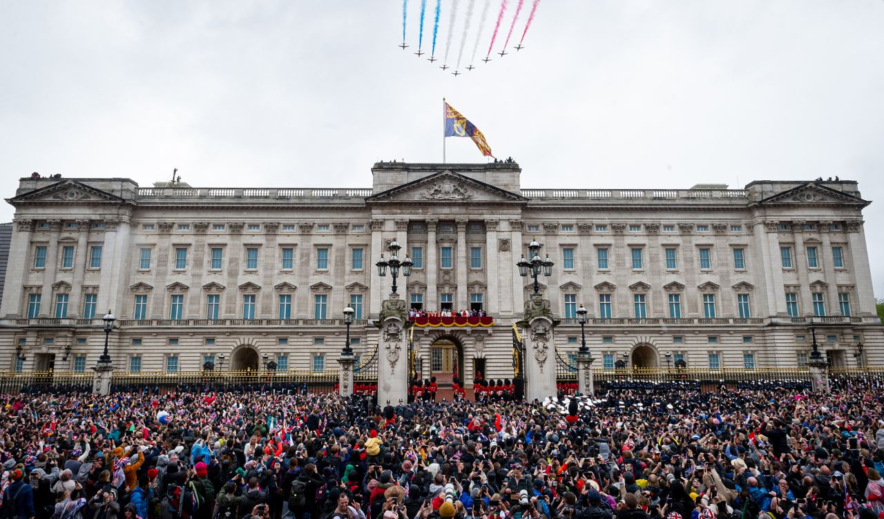 The crowd outside Buckingham Palace watches the Red Arrows fly by as the royals stand on the balcony.