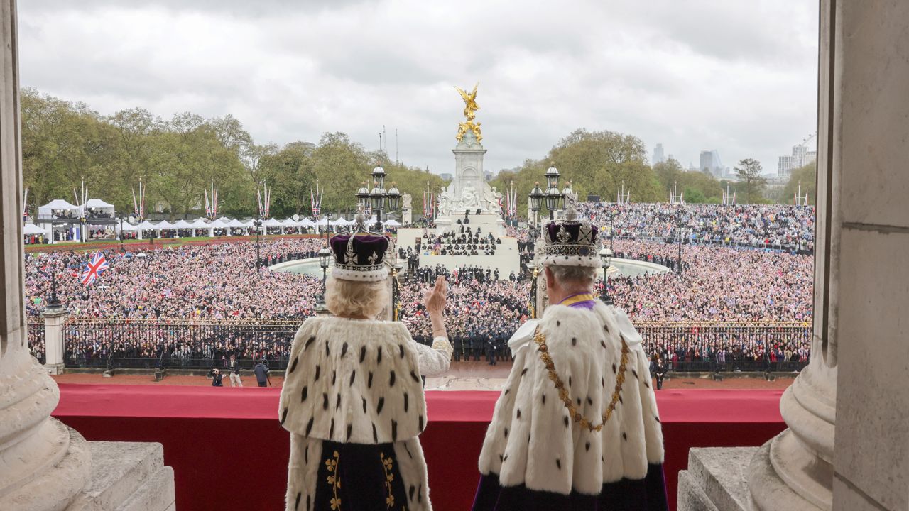 The newly crowned sovereign waves to crowds from Buckingham Palace. 