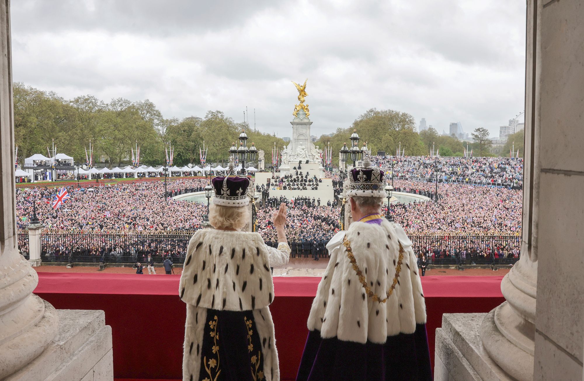 The King and Queen wave to people from the palace balcony.