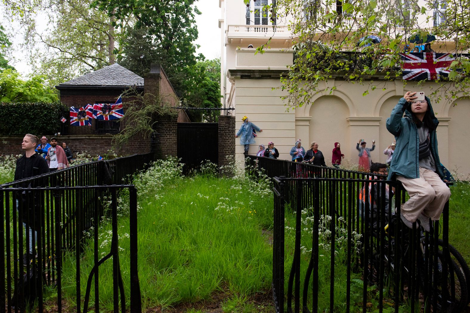 People wait on the procession route ahead of the coronation.