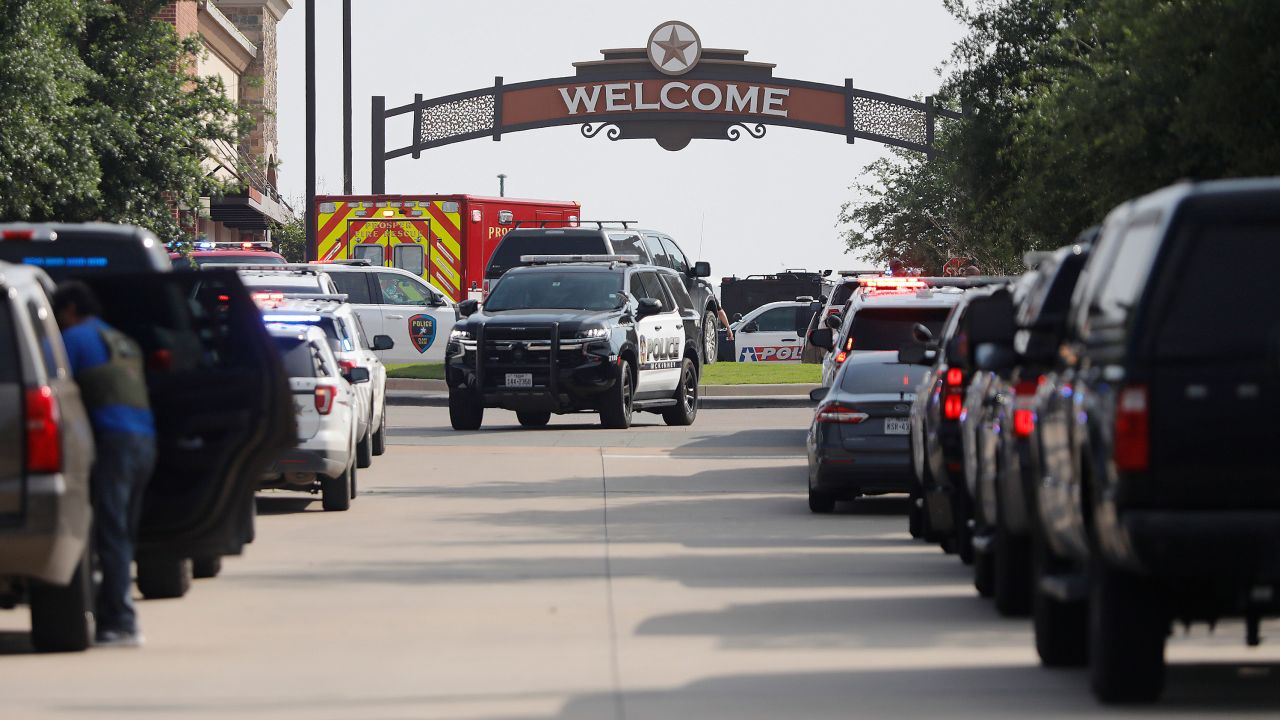 Emergency vehicles line the entrance to the Allen Premium Outlets where a shooting took place on May 6, 2023.
