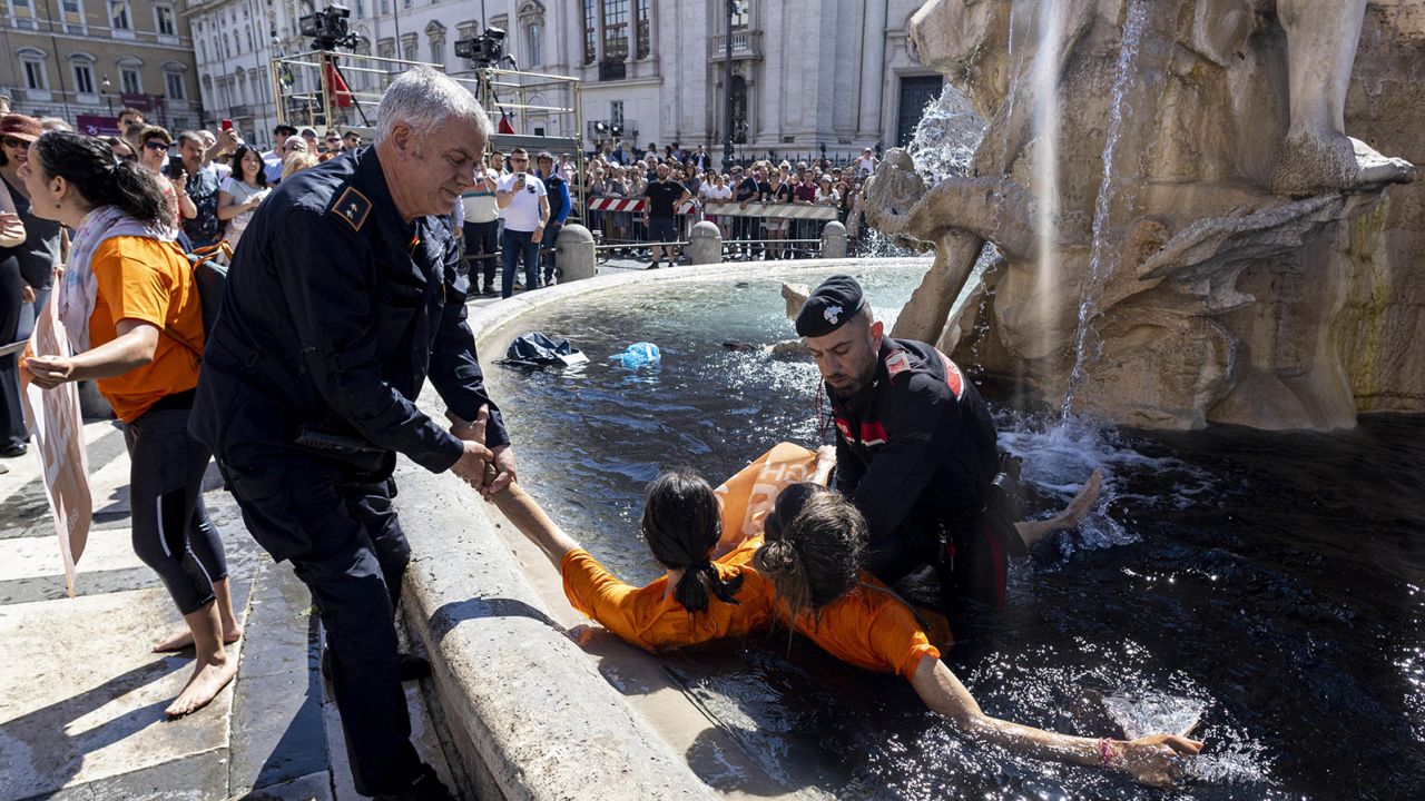 Last Generation climate activists are detained on May 6, 2023 after throwing a black liquid into the fountain in Rome.