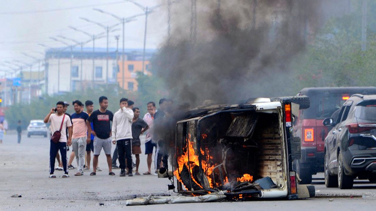 In this picture taken on May 4, 2023, smoke billows from a vehicle allegedly burned by the Meitei community tribals protesting to demand inclusion under the Scheduled Tribe category, in Imphal the capital of India's Manipur state.