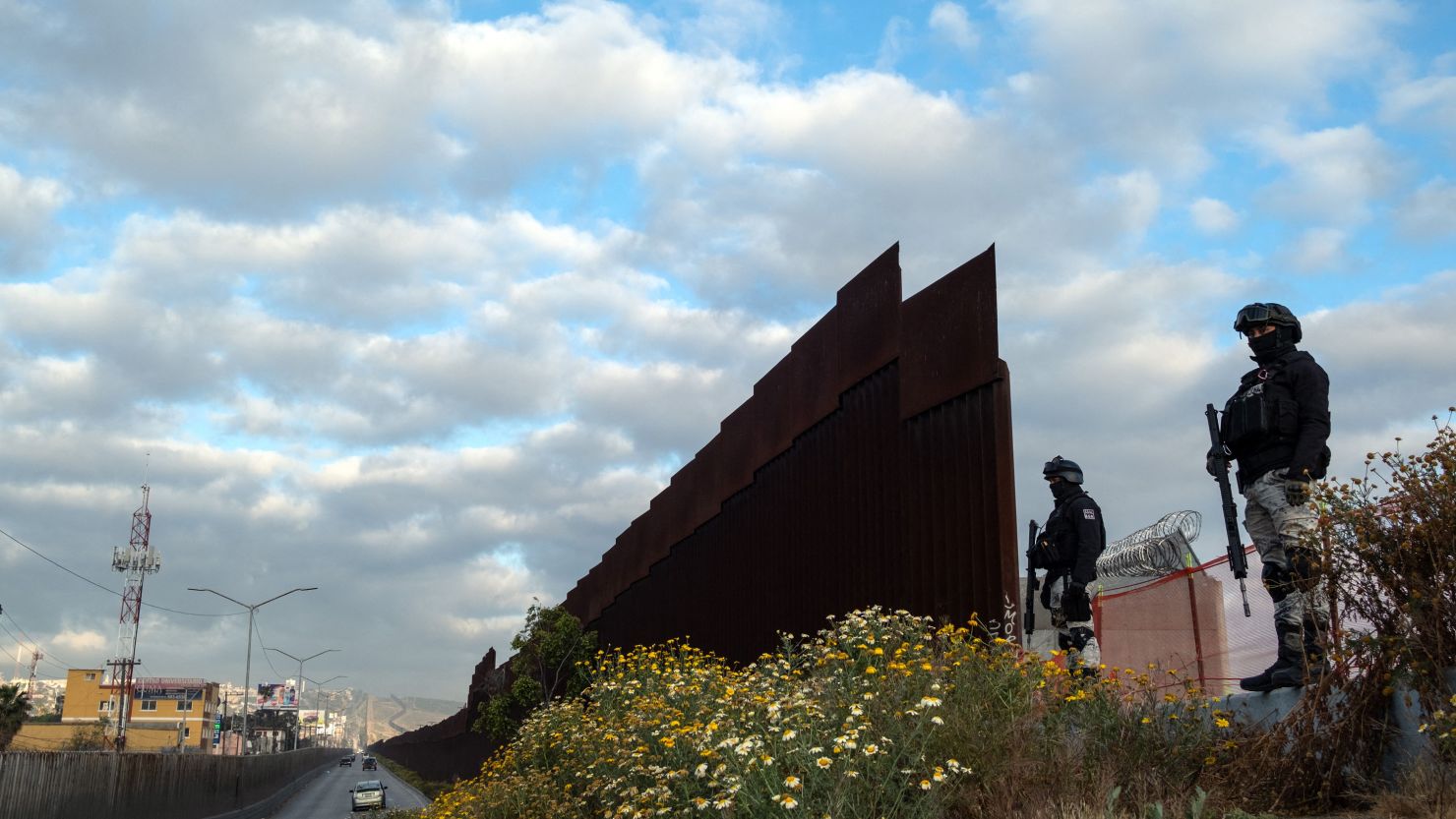 Mexican National Guard officers in Tijuana guard an open section of the US-Mexico border wall on May 6, 2023.