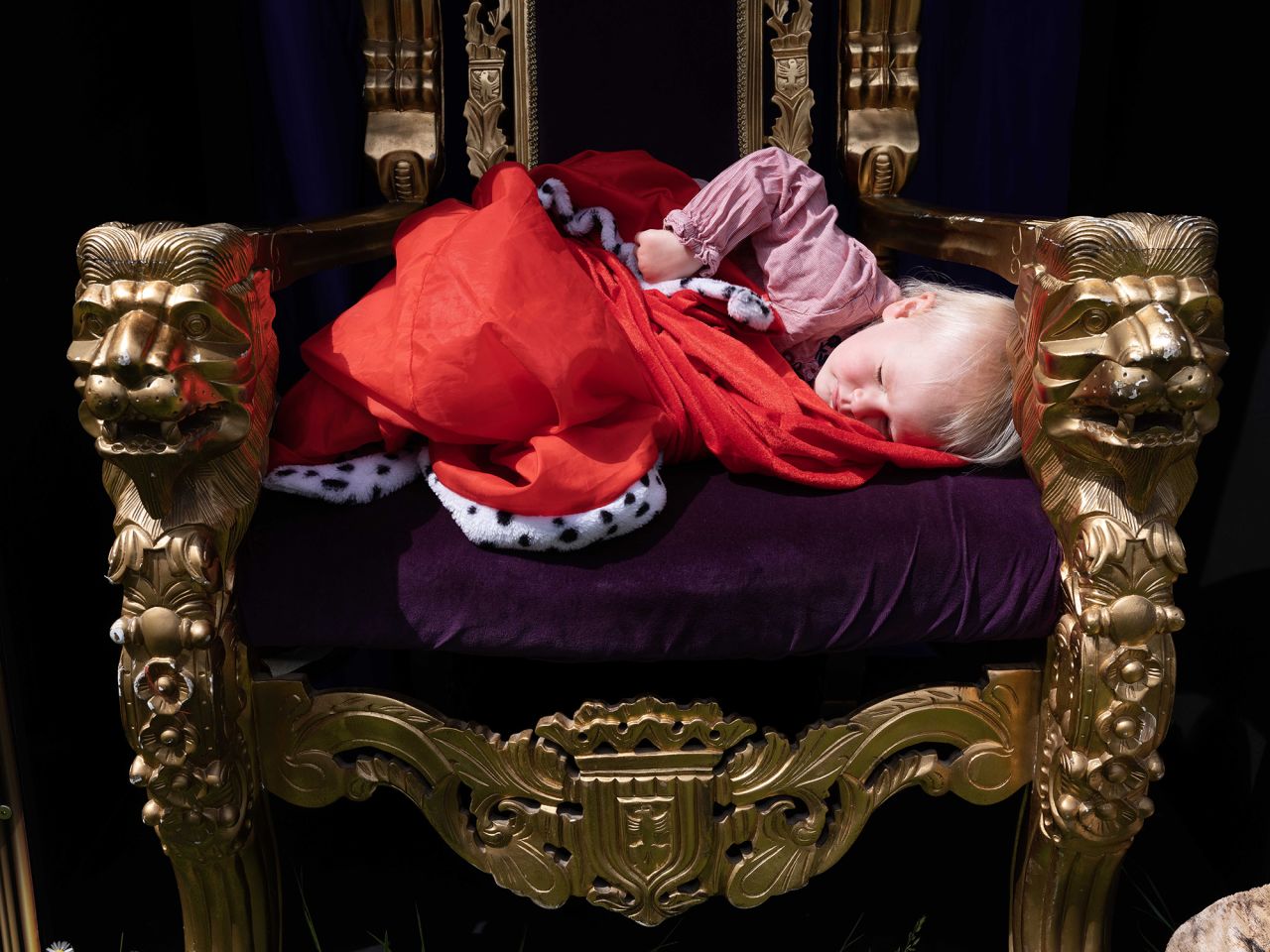 A child sleeps on a throne at a street party in London's Brixton district.