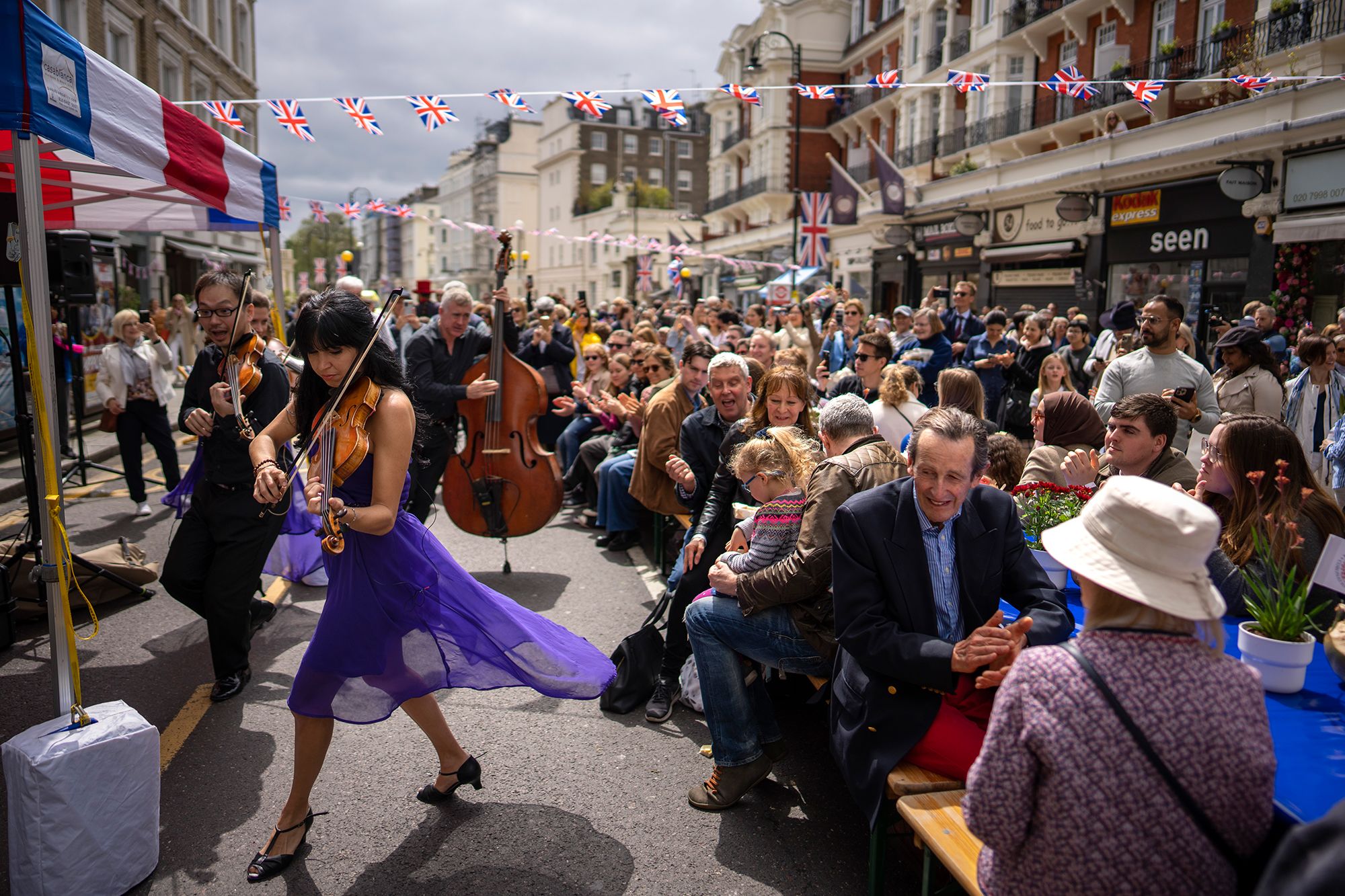 Musicians play while people take part in the 'Coronation Big Lunch' in London on Sunday.