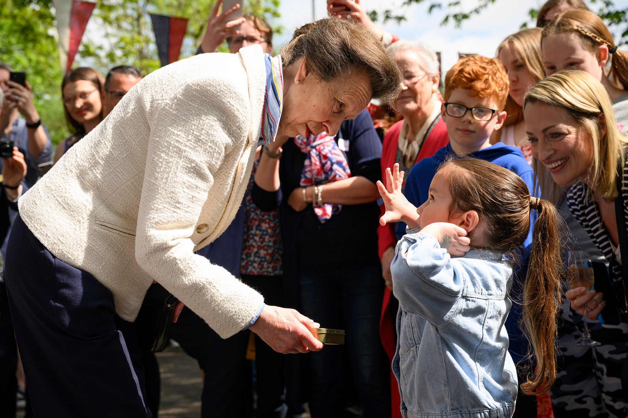 Princess Anne presents a young girl with a commemorative tin of old coins during celebrations in Swindon, England.