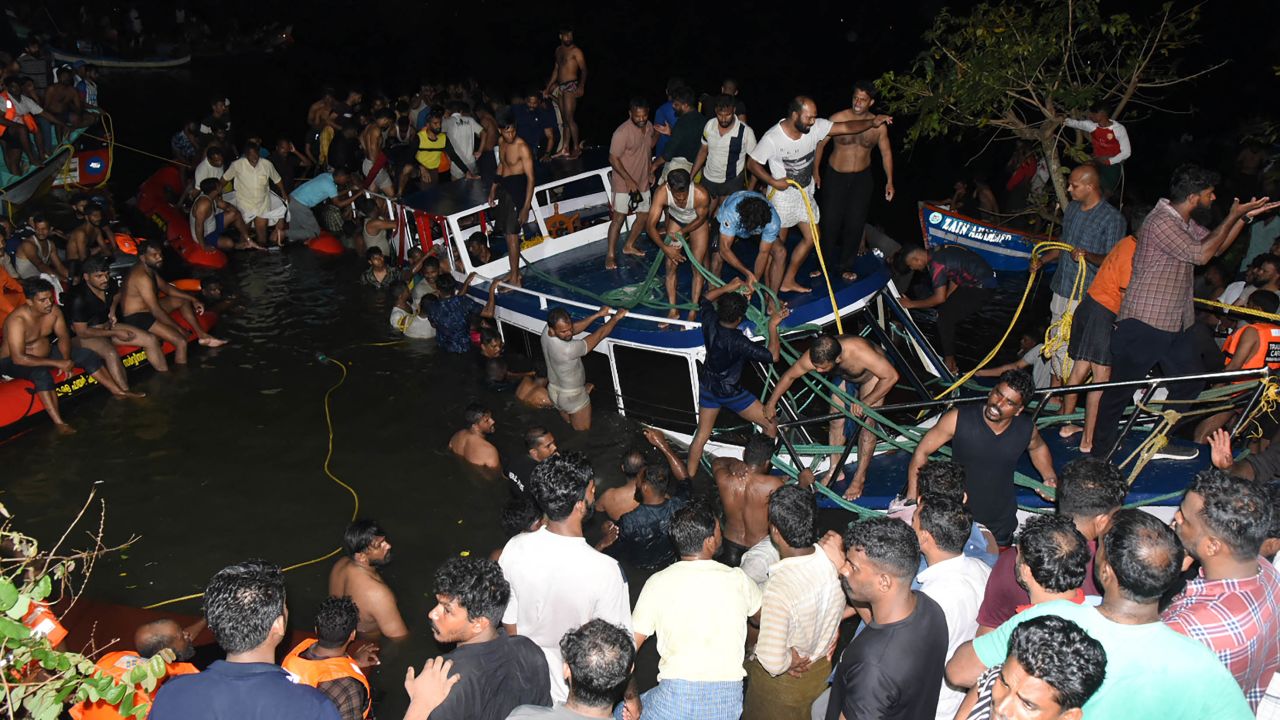 People attempt to rescue trapped tourists at the site of a boat accident in Tanur, in Malappuram district of India's Kerala state.