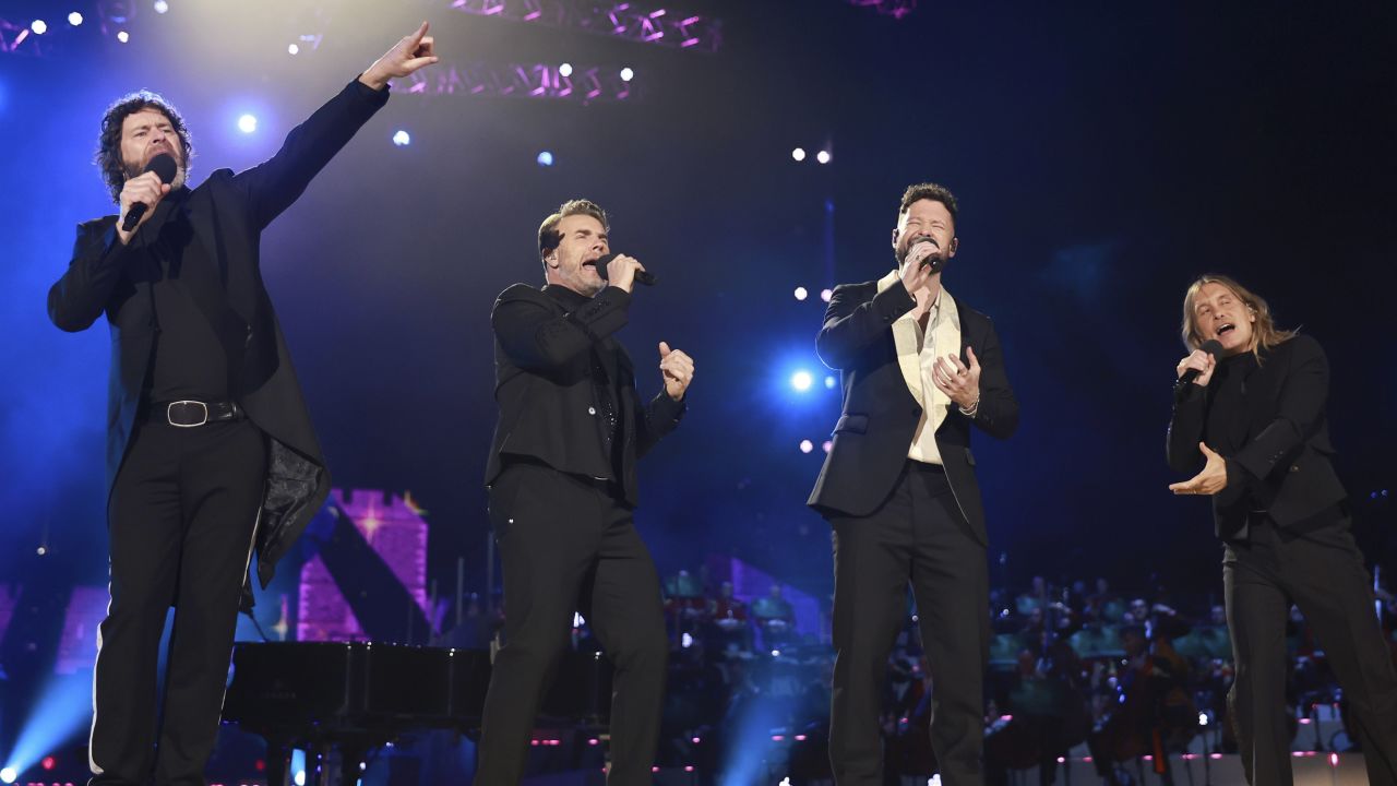 Gary Barlow, Howard Donald and Mark Owen of Take That perform with Calum Scott.