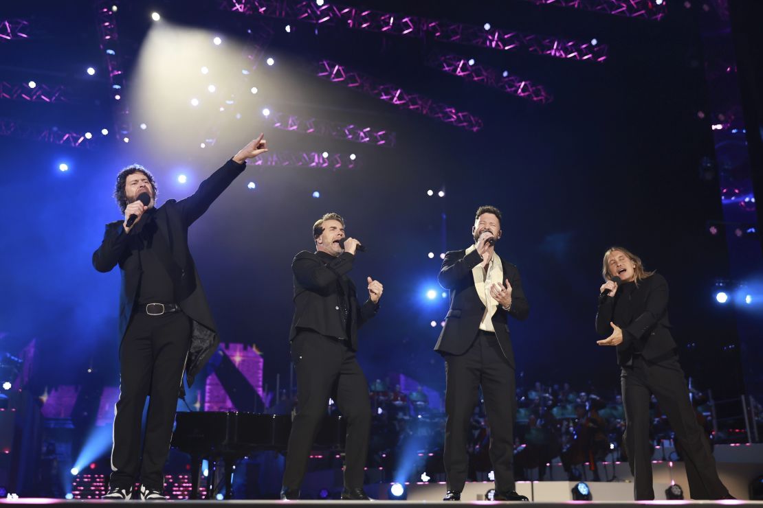 Gary Barlow, Howard Donald and Mark Owen of Take That perform with Calum Scott. 